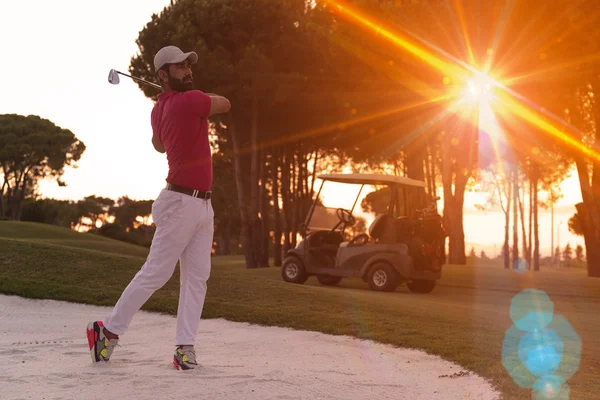Golfista colpire un bunker di sabbia colpo al tramonto — Foto Stock