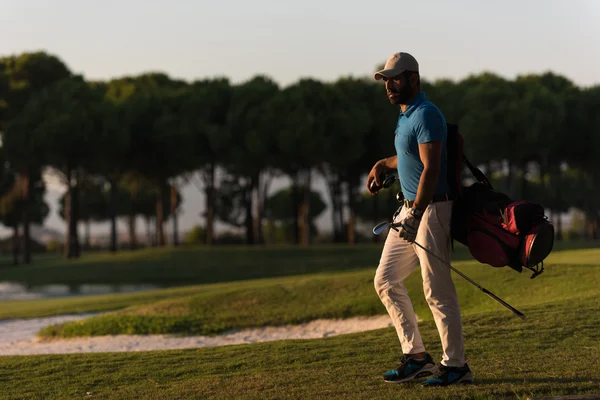 Golfista che cammina e porta borsa da golf al bellissimo tramonto — Foto Stock