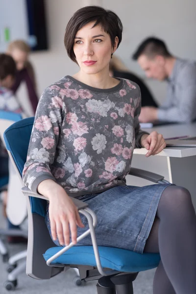 Portret van jonge zakenvrouw op kantoor met team op vergadering — Stockfoto
