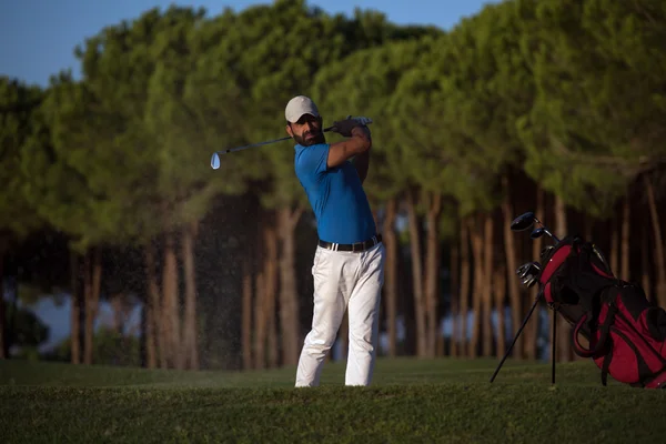 Golfista batendo um bunker de areia tiro no pôr do sol — Fotografia de Stock