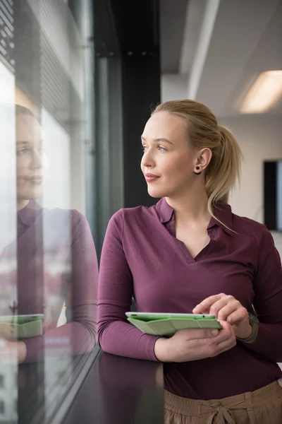 Femme d'affaires blonde travaillant sur tablette au bureau — Photo