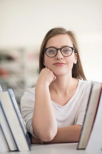 Portrét studentka vyberete knihu ke čtení v knihovně — Stock fotografie