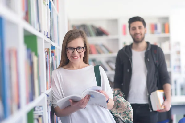 Paar van de studenten in de schoolbibliotheek — Stockfoto