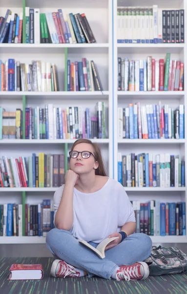 Famale studente lettura libro in biblioteca — Foto Stock