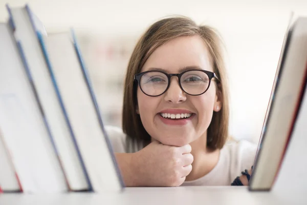 Retrato de estudante do sexo feminino selecionando livro para ler na biblioteca — Fotografia de Stock