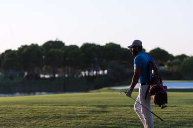 yürüyüş ve güzel günbatımı golf çantası taşıyan golfçü