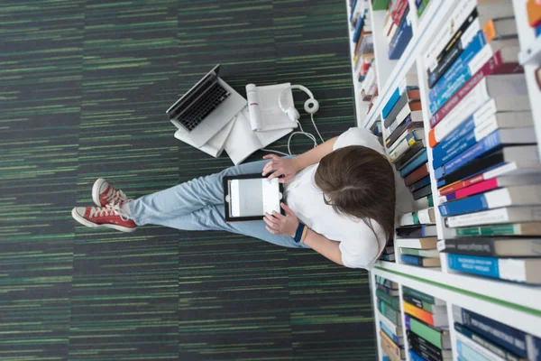 Vrouwelijke student studie in bibliotheek met behulp van tablet en zoeken — Stockfoto