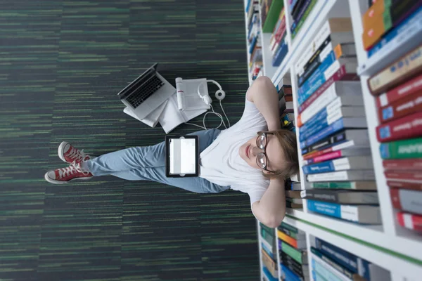 Vrouwelijke student studie in bibliotheek met behulp van tablet en zoeken — Stockfoto