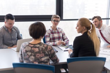 Genç iş adamları modern ofiste toplanıyor.