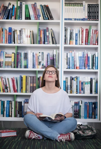 Famale student leesboek in bibliotheek — Stockfoto