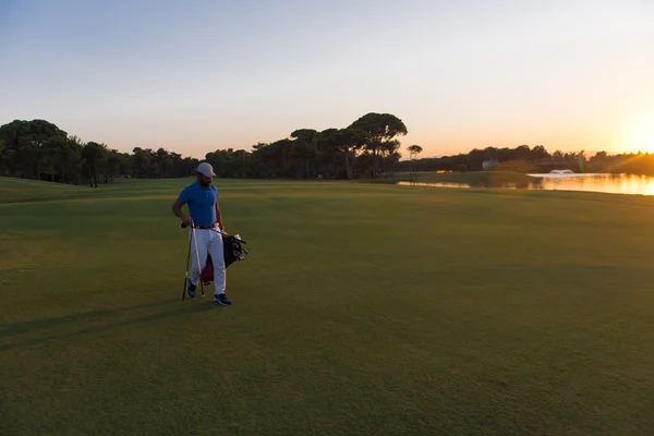 Golfspelare promenader och golf väska i vackra solnedgången — Stockfoto