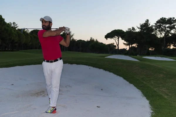 Golfeur frapper un sable bunker coup au coucher du soleil — Photo