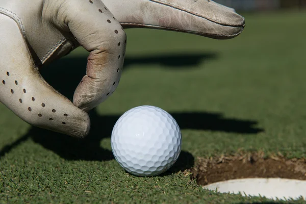 Ręka mężczyzny umieszczenie piłeczki do golfa w otwór — Zdjęcie stockowe
