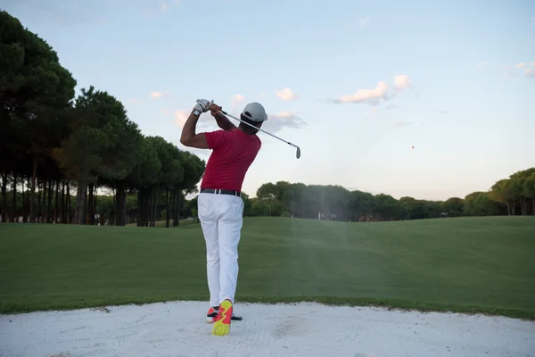 Golfista batendo um bunker de areia tiro no pôr do sol — Fotografia de Stock