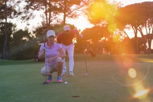 Casal no campo de golfe ao pôr-do-sol — Fotografia de Stock
