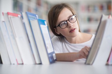 kitaplıkta okumak için kitap seçme famale öğrenci portresi