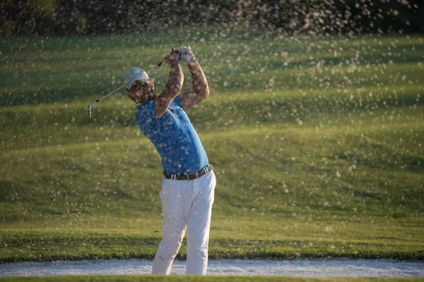 Golfista golpeando un tiro bunker de arena en la puesta del sol — Foto de Stock