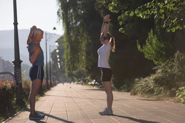 Paar warming up en stretching voor het joggen — Stockfoto