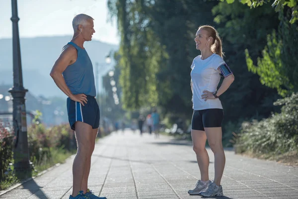 Joggingpaar plant Laufstrecke und legt Musik auf — Stockfoto