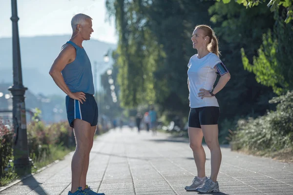 Jogging couple planning running route  and setting music — Stock Photo, Image