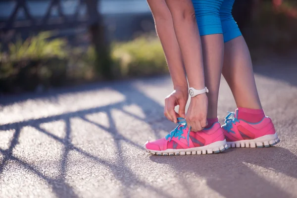 Zbliżenie kobiety wiązanie butów do biegania — Zdjęcie stockowe