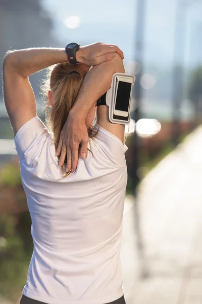 Mulher loira se alongando antes de correr pela manhã — Fotografia de Stock