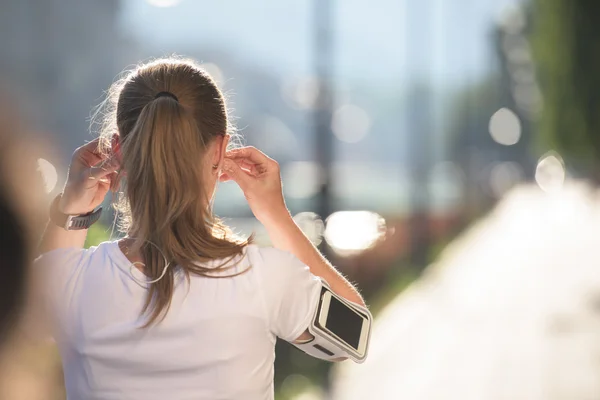 Jogging donna impostazione telefono prima di fare jogging — Foto Stock