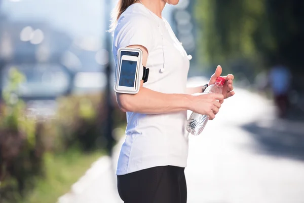 Žena pitná voda po joggingu — Stock fotografie