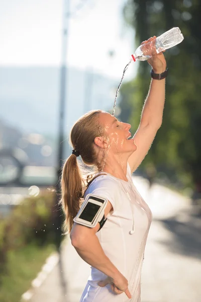 Kadın koşudan sonra su içiyor. — Stok fotoğraf