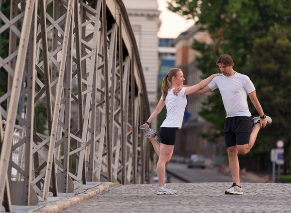 Casal aquecimento e alongamento antes de correr — Fotografia de Stock