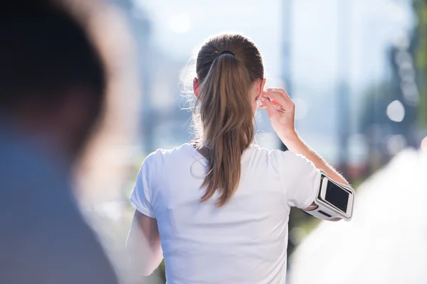 Jogging donna impostazione telefono prima di fare jogging — Foto Stock