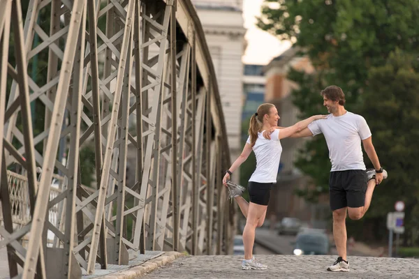 Para rozgrzewa się i rozciąga przed joggingiem — Zdjęcie stockowe