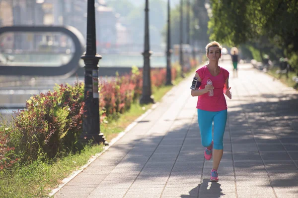 Sporty woman running  on sidewalk — Stock Photo, Image
