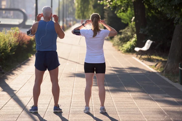 Joggingpaar plant Laufstrecke und legt Musik auf — Stockfoto