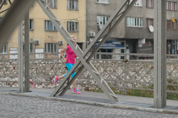 Donna sportiva che corre sul marciapiede — Foto Stock