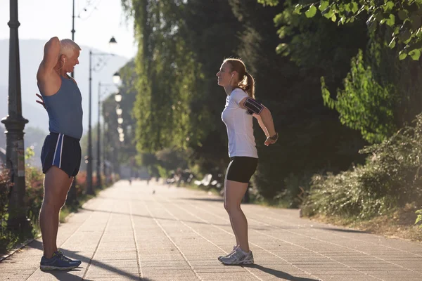 Casal aquecimento e alongamento antes de correr — Fotografia de Stock