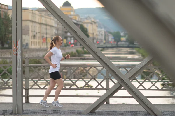Donna sportiva che corre sul marciapiede — Foto Stock