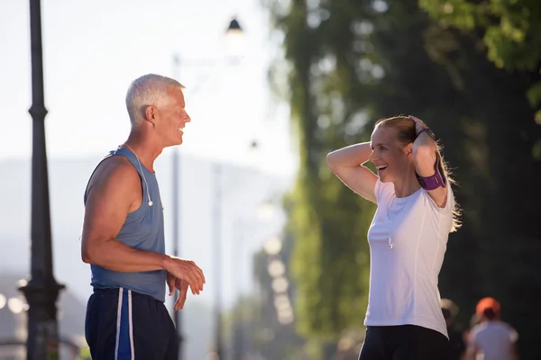 Joggingpaar plant Laufstrecke und legt Musik auf — Stockfoto