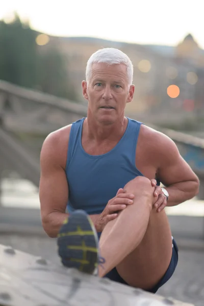 Handsome man stretching before jogging — Stock Photo, Image