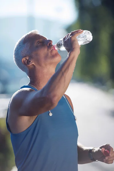 Senior joggt Mann trinkt frisches Wasser aus Flasche — Stockfoto