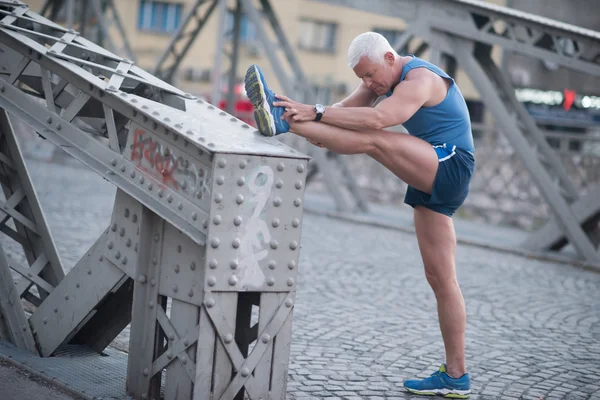 Bel homme étirement avant le jogging — Photo