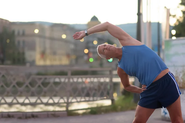 Pohledný muž, táhnoucí se před jogging — Stock fotografie