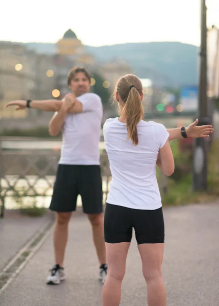 Couple warming up before jogging — Stock Photo, Image