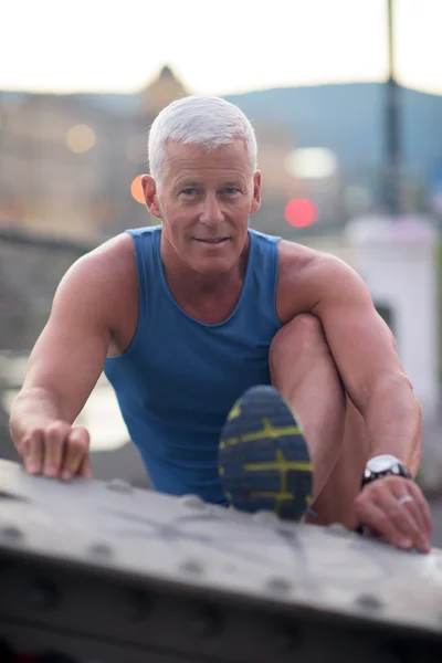 Handsome man stretching before jogging — Stock Photo, Image