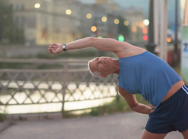 Schöner Mann dehnt sich vor dem Joggen — Stockfoto