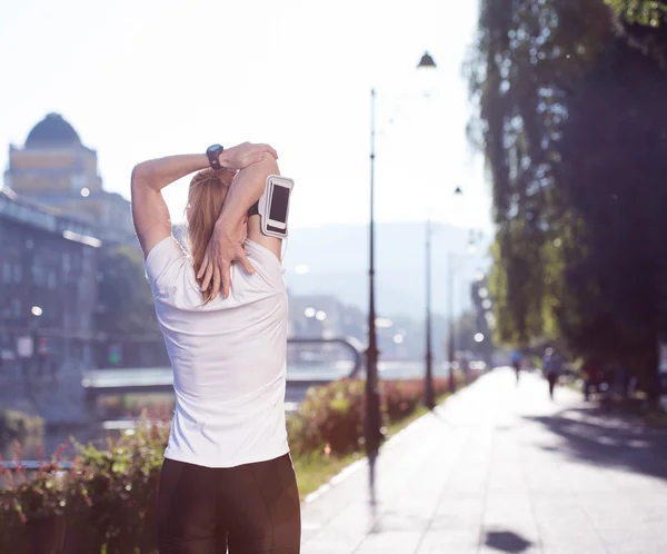 Blondýnka, táhnoucí se před ranní jogging — Stock fotografie