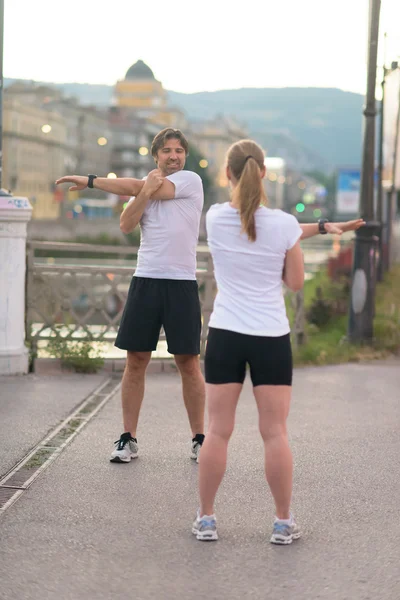 Pareja calentando antes de trotar — Foto de Stock