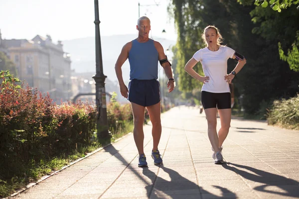 Jogging couple planning running route  and setting music — Stock Photo, Image