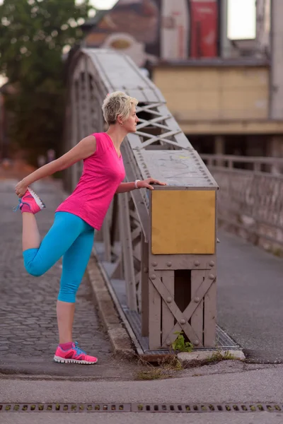 Blondýnka, táhnoucí se před ranní jogging — Stock fotografie