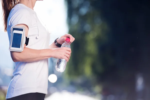 Žena pitná voda po joggingu — Stock fotografie